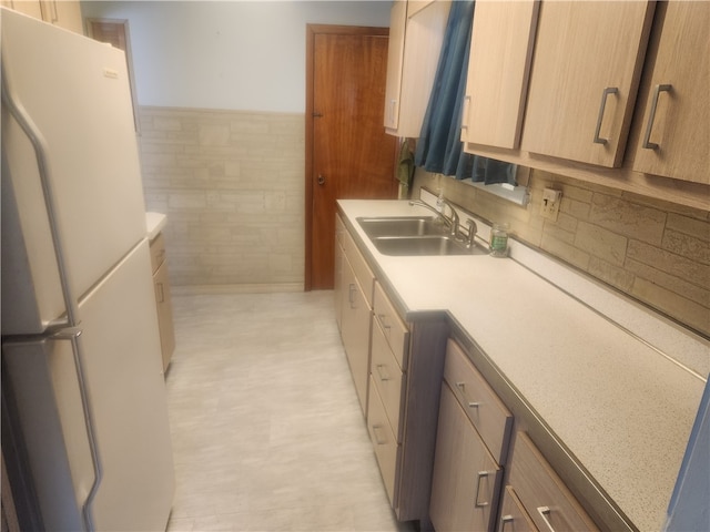 kitchen featuring tile walls, sink, and white refrigerator