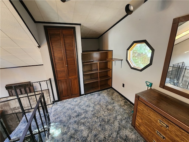 interior space with crown molding and dark carpet