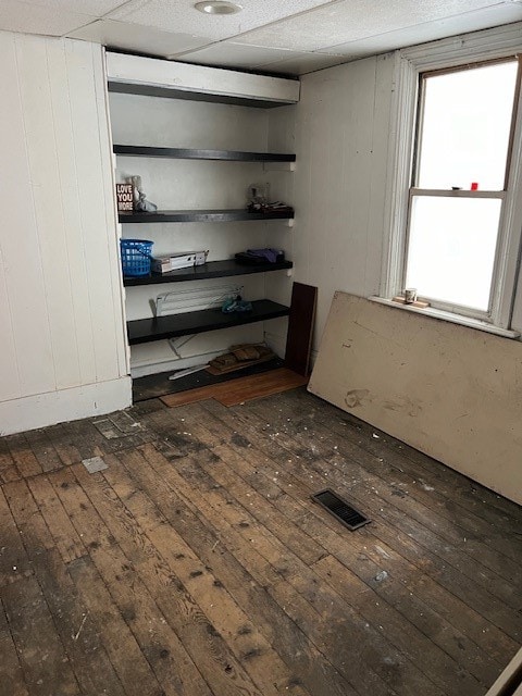 spare room featuring dark wood-type flooring and wood walls