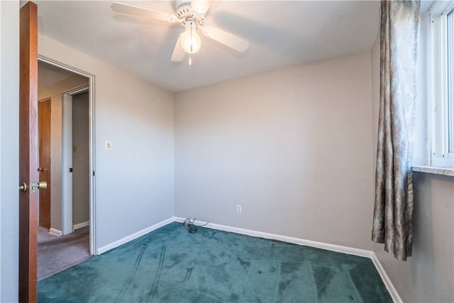 empty room featuring ceiling fan and dark carpet