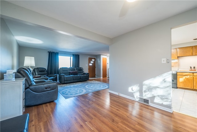 living room featuring sink, hardwood / wood-style flooring, and ceiling fan