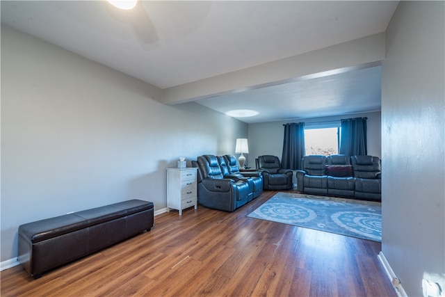 living room featuring dark wood-type flooring and ceiling fan