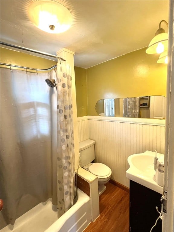 full bathroom with hardwood / wood-style flooring, vanity, shower / bath combo, and toilet