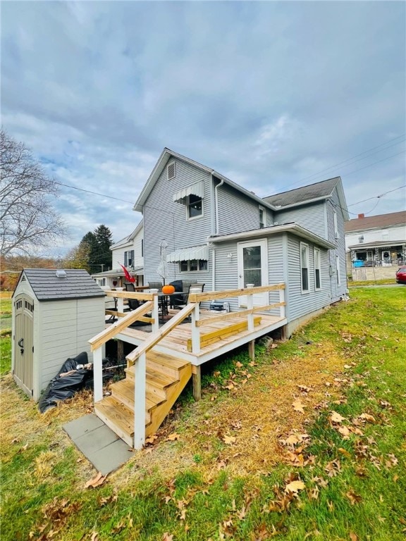 rear view of house with a shed, a lawn, and a wooden deck