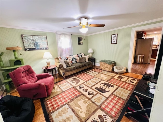 living room with hardwood / wood-style floors, ceiling fan, and crown molding