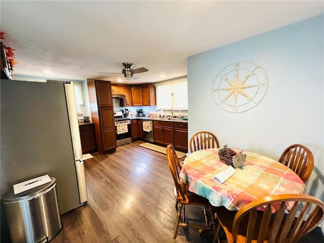 dining space with hardwood / wood-style floors, ceiling fan, and sink