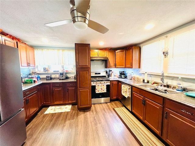 kitchen with light hardwood / wood-style flooring, a textured ceiling, sink, ceiling fan, and appliances with stainless steel finishes