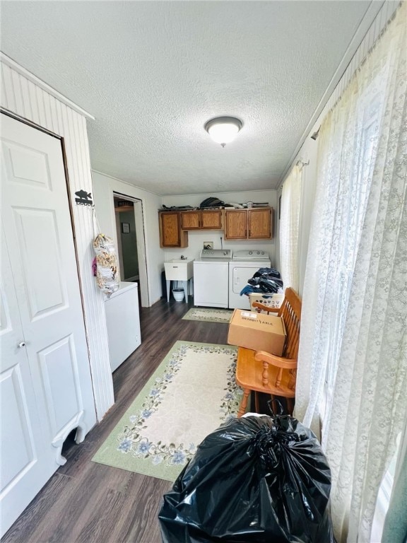 kitchen with dark wood-type flooring, a textured ceiling, sink, and independent washer and dryer