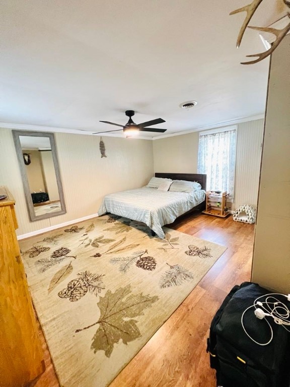 bedroom featuring crown molding, ceiling fan, and light hardwood / wood-style flooring