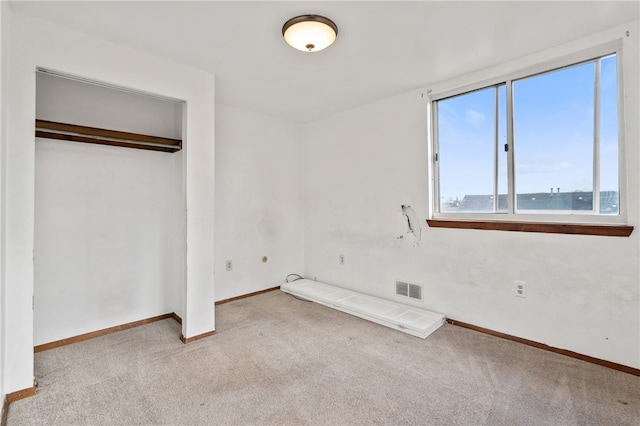 unfurnished bedroom featuring a closet and light carpet