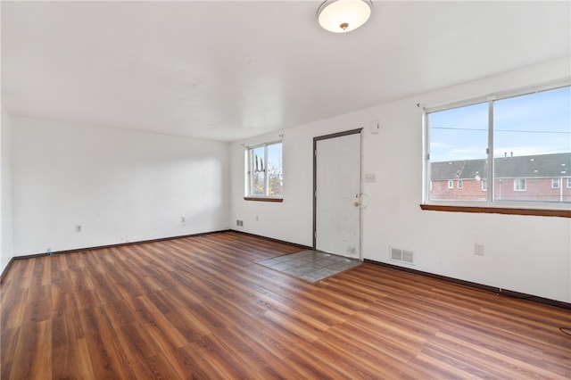 empty room with dark hardwood / wood-style flooring