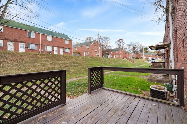 wooden terrace featuring central air condition unit and a lawn