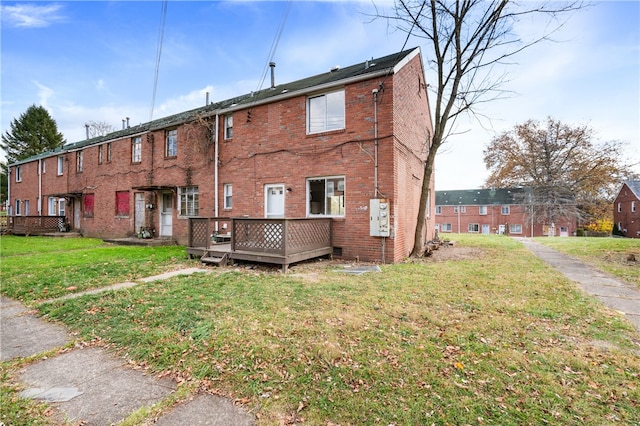 back of house featuring a wooden deck and a yard