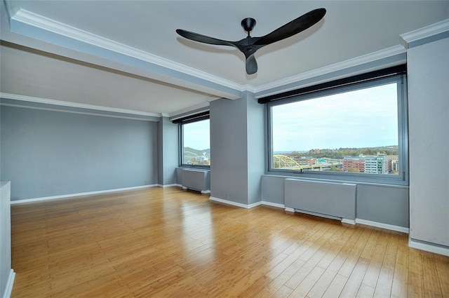 unfurnished room with hardwood / wood-style flooring, ornamental molding, and a healthy amount of sunlight