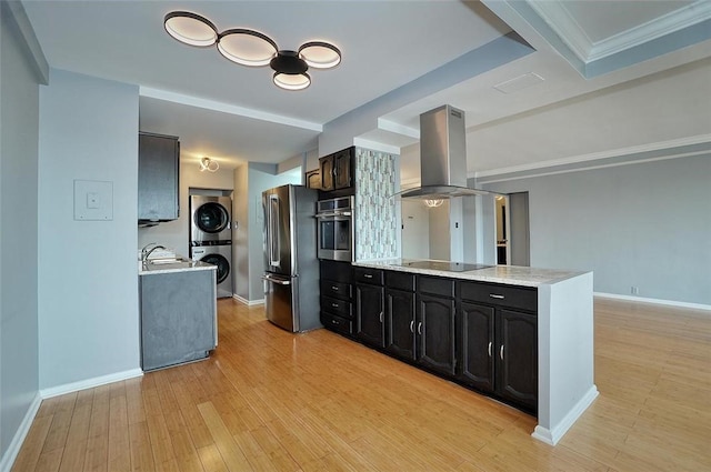 320 Fort Duquesne Blvd Unit 15H, Downtown Pgh, PA 15222 - kitchen with island range hood, stainless steel appliances, stacked washer / drying machine, a sink, and baseboards
