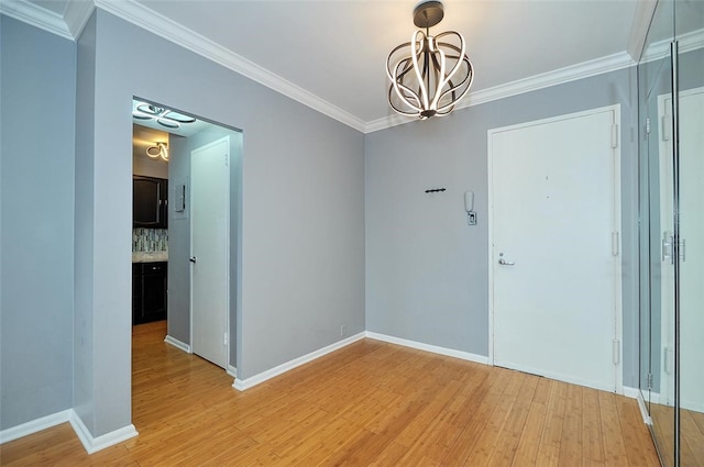 unfurnished dining area with an inviting chandelier, crown molding, and light hardwood / wood-style flooring