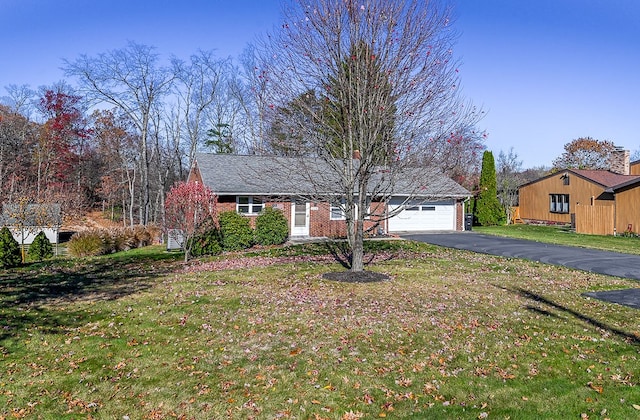 ranch-style house featuring a front lawn and a garage