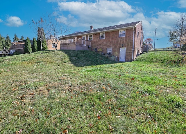 back of property with central AC unit and a yard