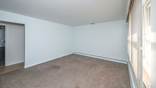 unfurnished room featuring carpet flooring and a baseboard heating unit