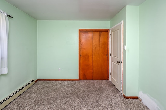 unfurnished bedroom with a baseboard heating unit, light carpet, and a closet