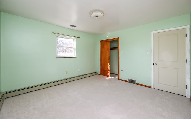 unfurnished bedroom featuring light colored carpet and a baseboard radiator