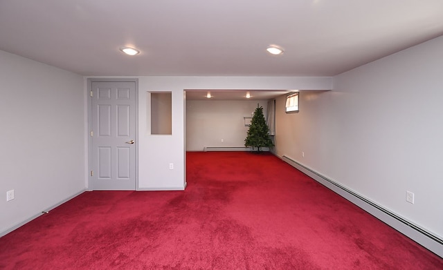 basement featuring carpet flooring and a baseboard heating unit