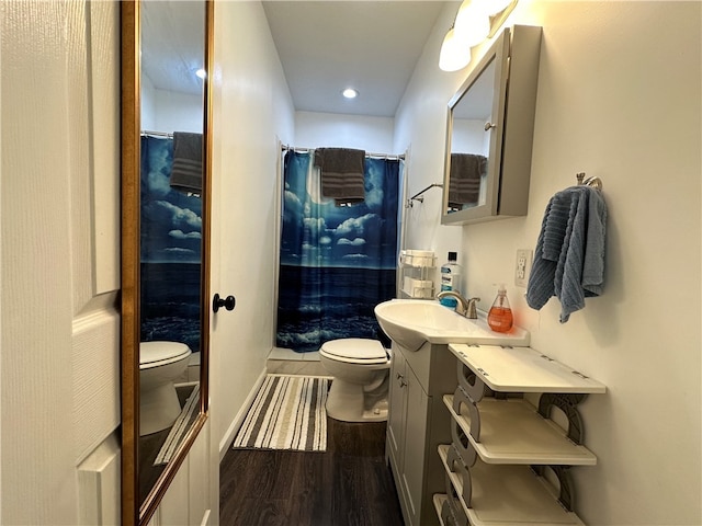 bathroom with hardwood / wood-style floors, toilet, and a shower with curtain