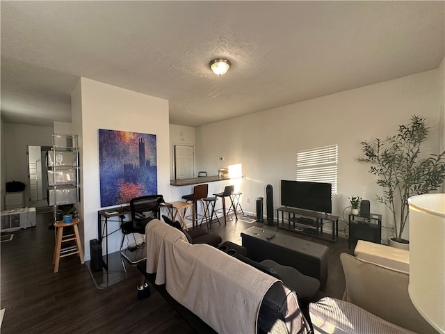 living room featuring a textured ceiling and dark hardwood / wood-style floors