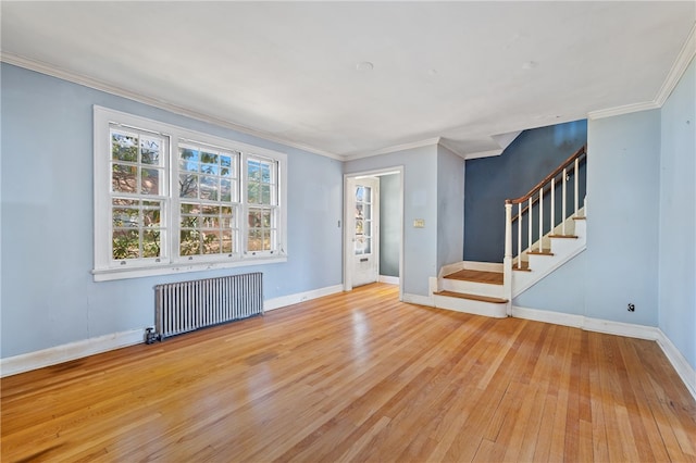 unfurnished living room featuring ornamental molding, wood-type flooring, and radiator