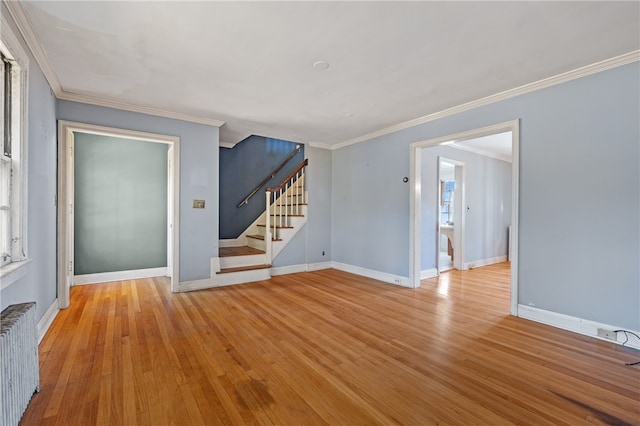 unfurnished room featuring radiator heating unit, light wood-type flooring, and ornamental molding