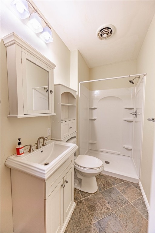 bathroom with a shower, vanity, and toilet