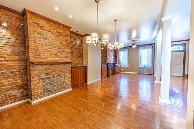 unfurnished living room with radiator heating unit, hardwood / wood-style flooring, and ornamental molding