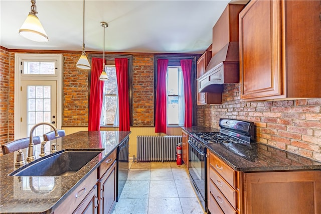 kitchen featuring radiator, brick wall, black appliances, and decorative light fixtures