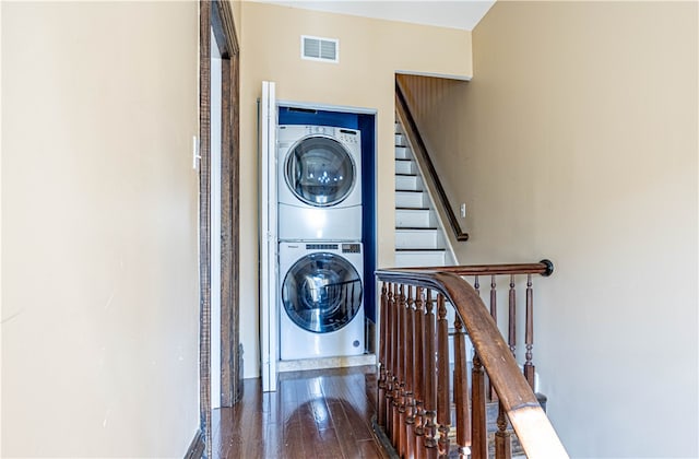 stairs featuring hardwood / wood-style floors and stacked washing maching and dryer