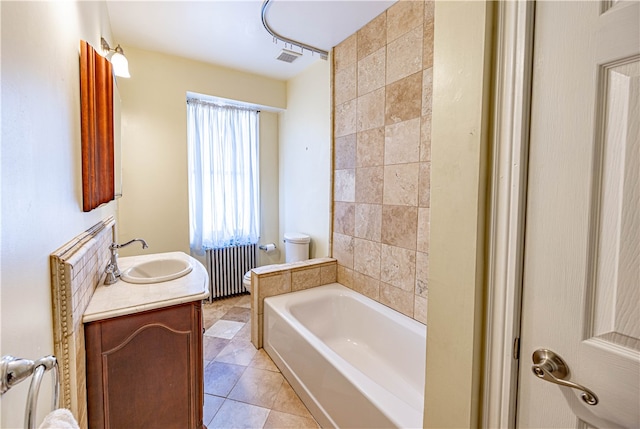 bathroom featuring radiator heating unit, tile patterned floors, toilet, a bathtub, and vanity