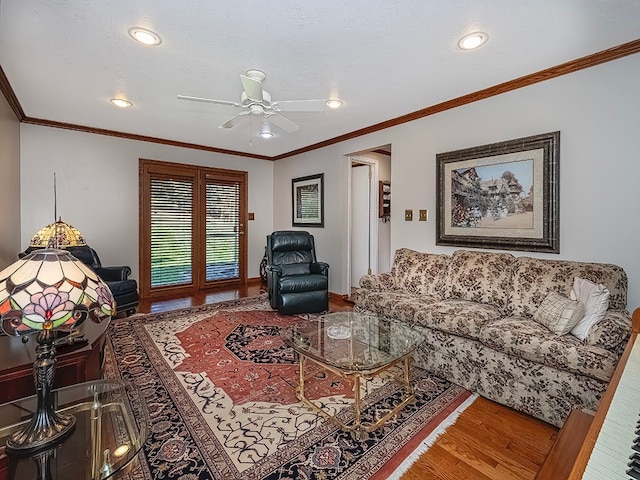 living room featuring hardwood / wood-style floors, ceiling fan, and crown molding