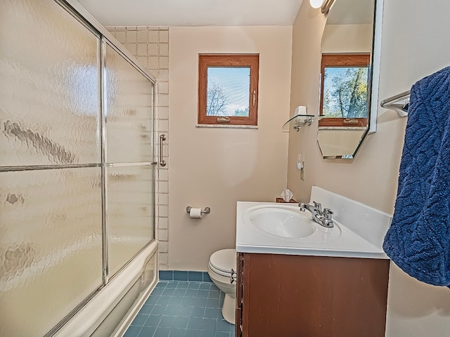 full bathroom featuring vanity, bath / shower combo with glass door, tile patterned floors, and toilet