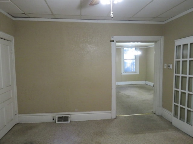 spare room featuring ceiling fan, light colored carpet, and a drop ceiling