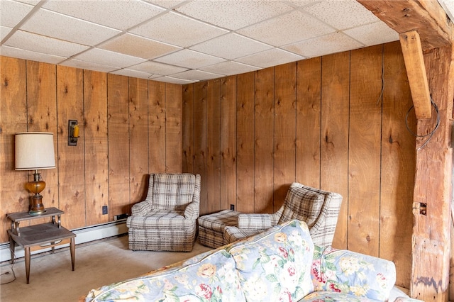 bedroom featuring a drop ceiling, wooden walls, and carpet