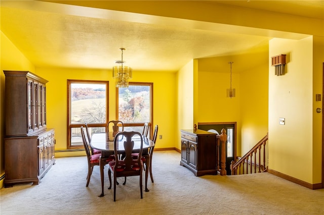 dining room featuring light carpet, a baseboard heating unit, and a notable chandelier