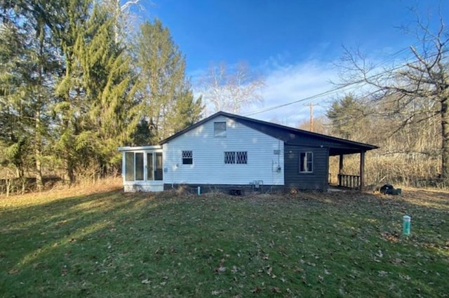 back of property with a sunroom and a yard