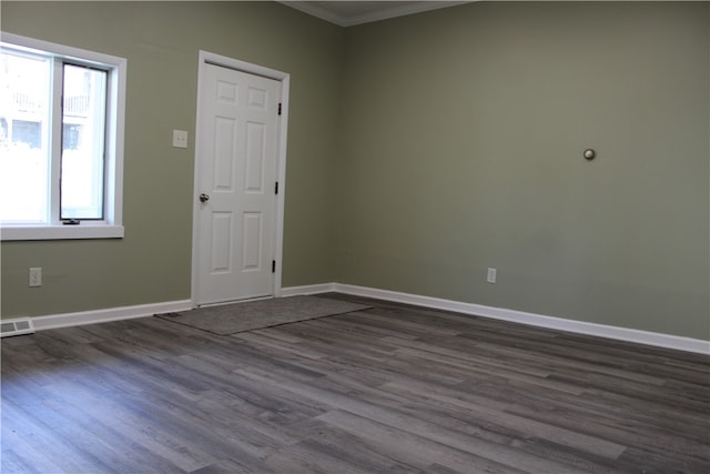 foyer entrance with ornamental molding and dark wood-type flooring