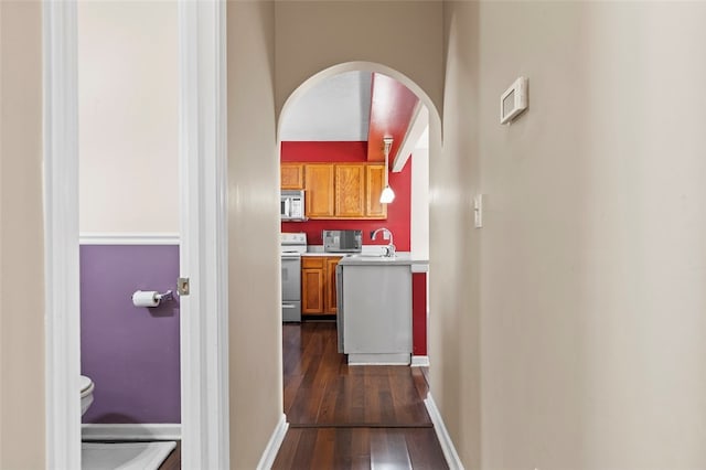 corridor featuring dark wood-type flooring and sink