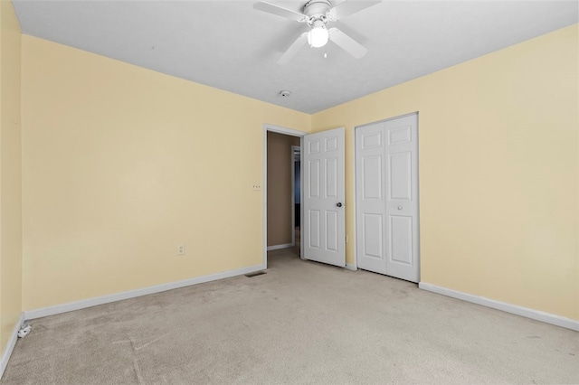 unfurnished bedroom featuring a closet, light colored carpet, and ceiling fan