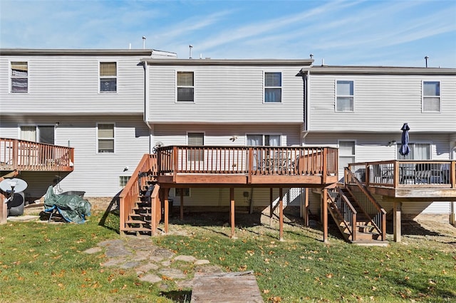 back of property with a wooden deck and a yard