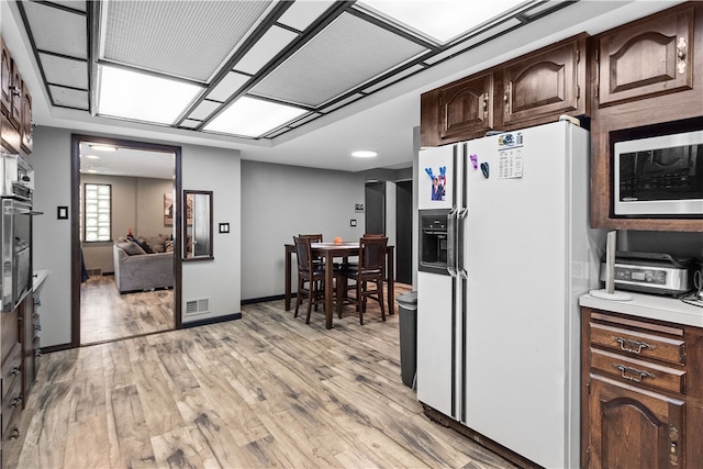 kitchen featuring light wood-type flooring, dark brown cabinetry, and stainless steel appliances