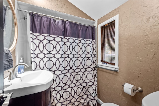 bathroom with toilet, a shower with curtain, vanity, and vaulted ceiling