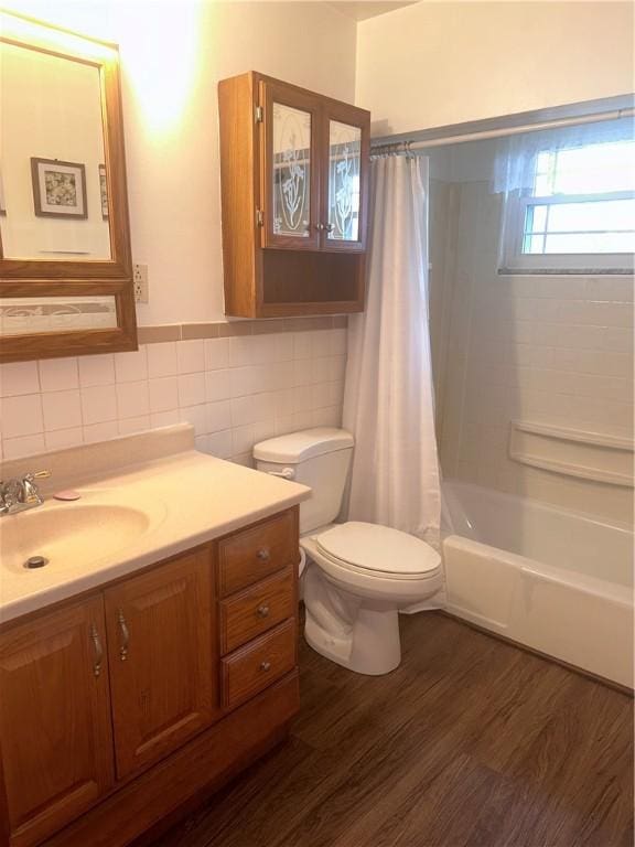 full bathroom with shower / bath combination with curtain, wood-type flooring, toilet, vanity, and tile walls