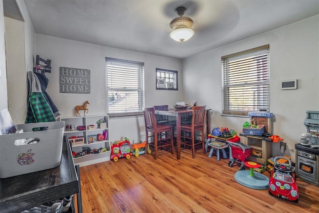 recreation room with wood-type flooring, ceiling fan, and plenty of natural light