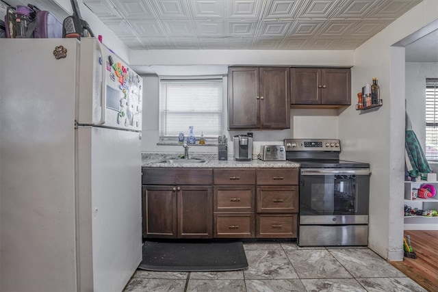 kitchen featuring light hardwood / wood-style floors, stainless steel electric range, a wealth of natural light, and white fridge